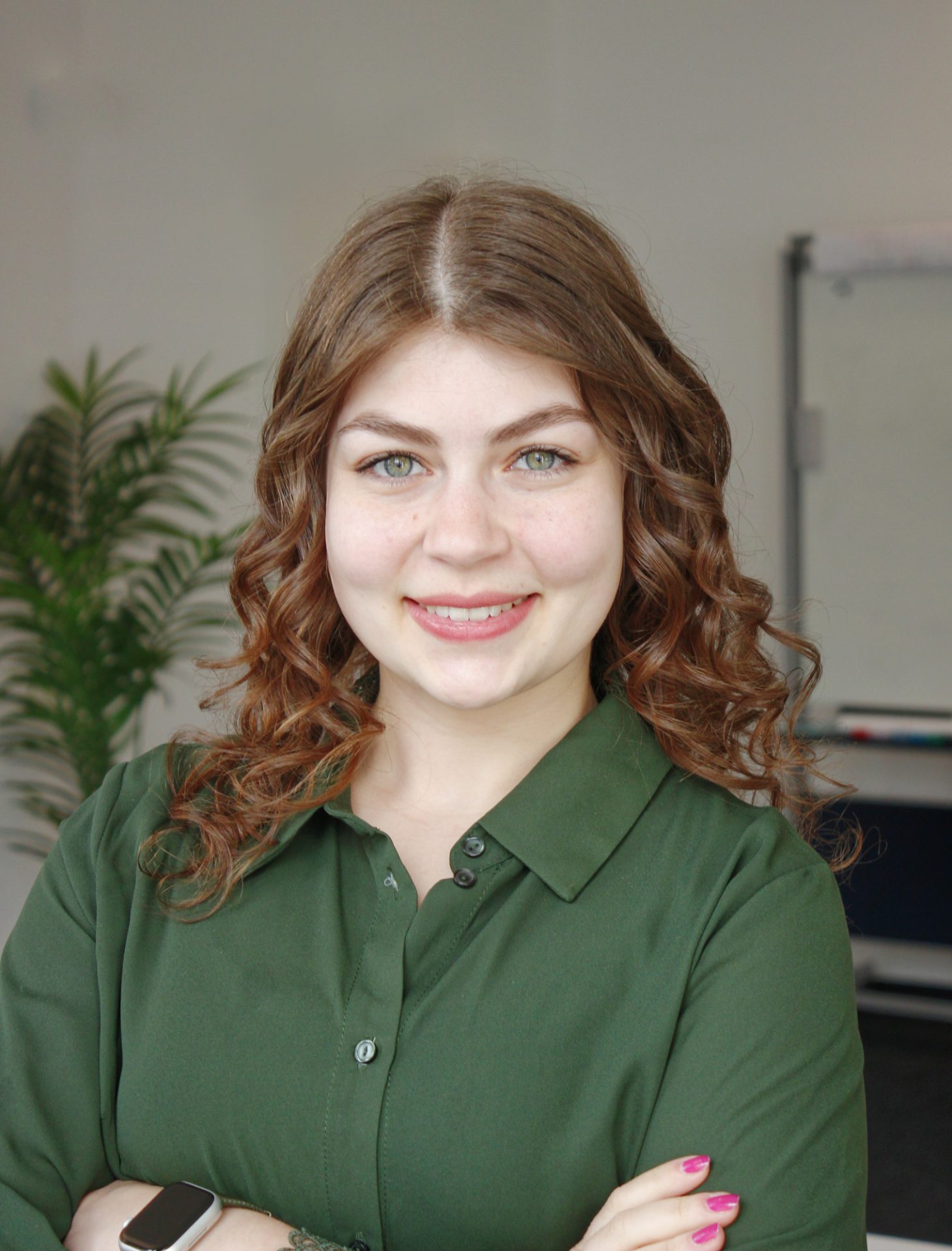 Auf dem Foto ist die Personalerin von SAC zu sehen. Sie hat braune Locken, grüne Augen und ein entschlossenes, sowie freundliches Lächeln.